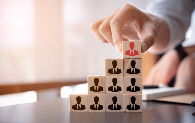 Midsection of businesswoman stacking wooden team blocks at table