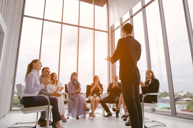 Businessman speaker giving a talk at business meeting. Audience in conference room