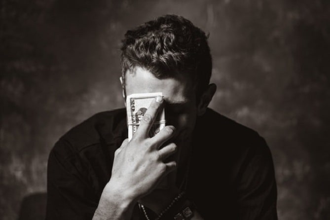 A man holdink stack of banknotes near to his face