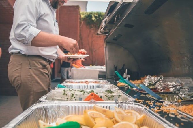 A person plating food from boxed food plates