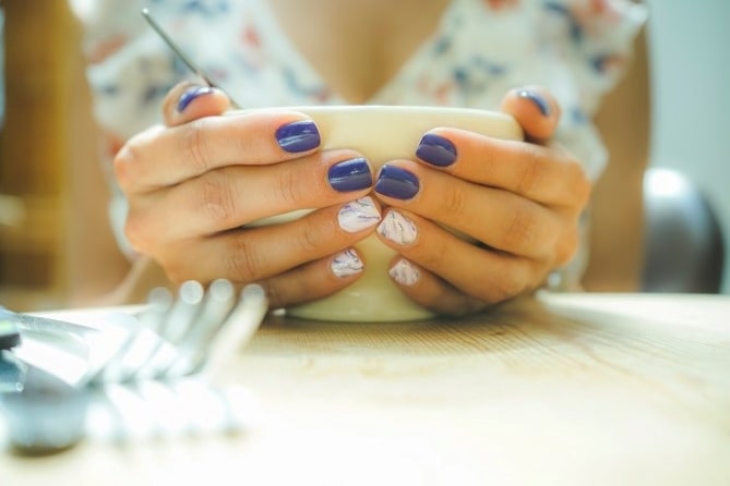 a person choosing a color for nail styling while learning how to become a manicurist
