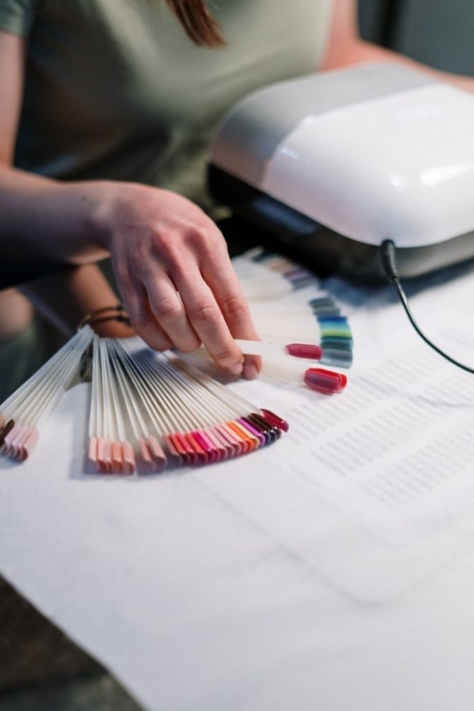 a person choosing a color for nail styling