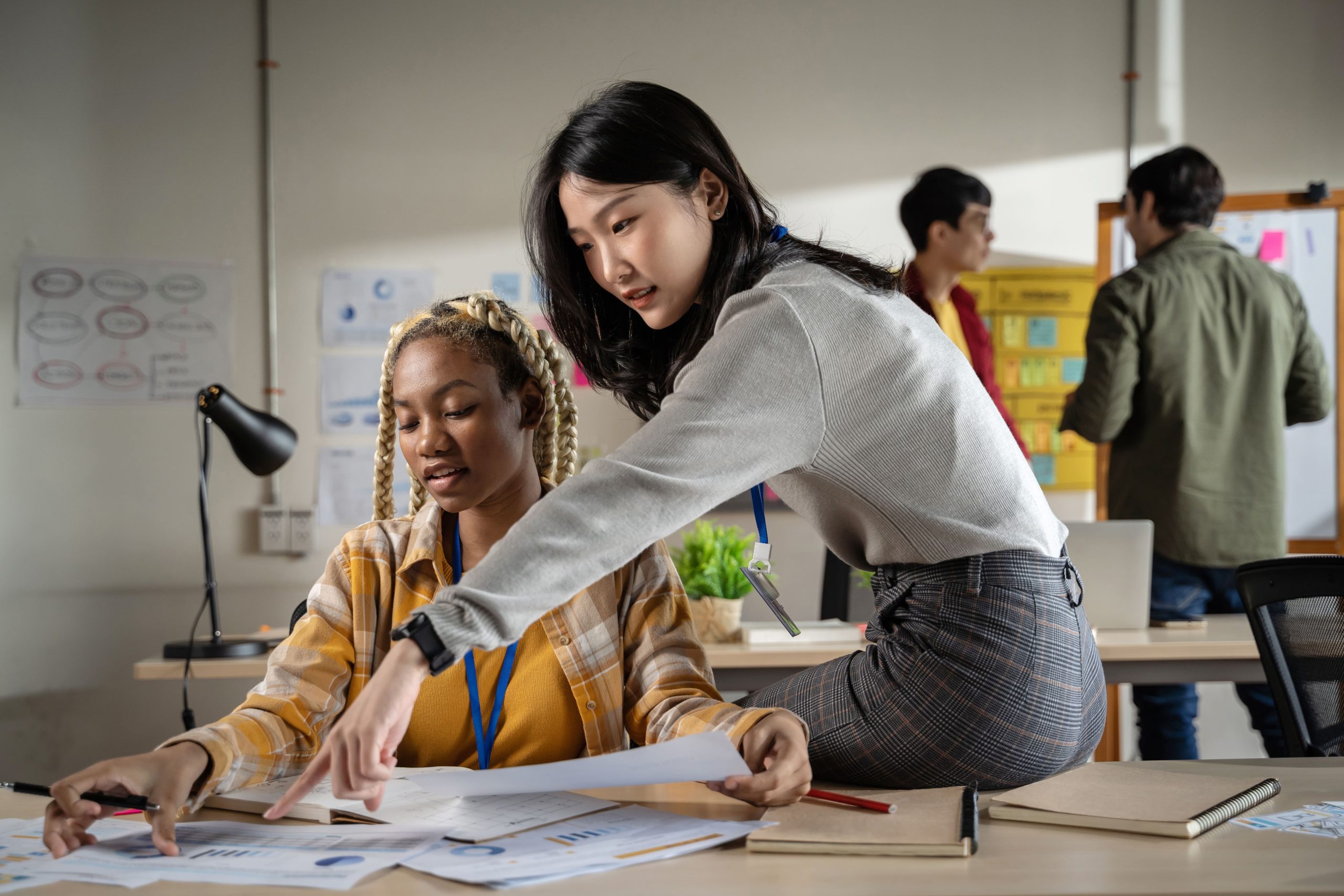 A young woman learning from an expert in a work environment