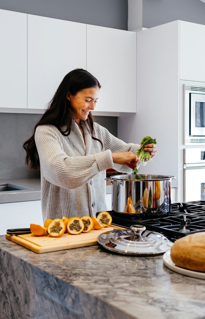 woman smiling while cooking