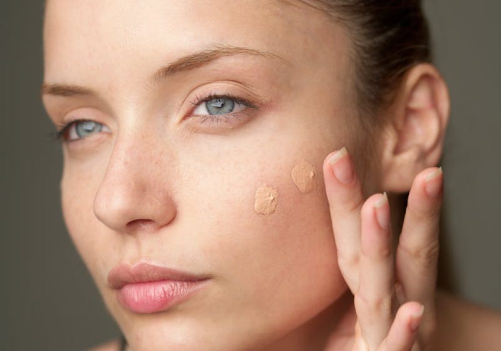 Close-up of a woman applying foundation, highlighting a natural skincare routine.