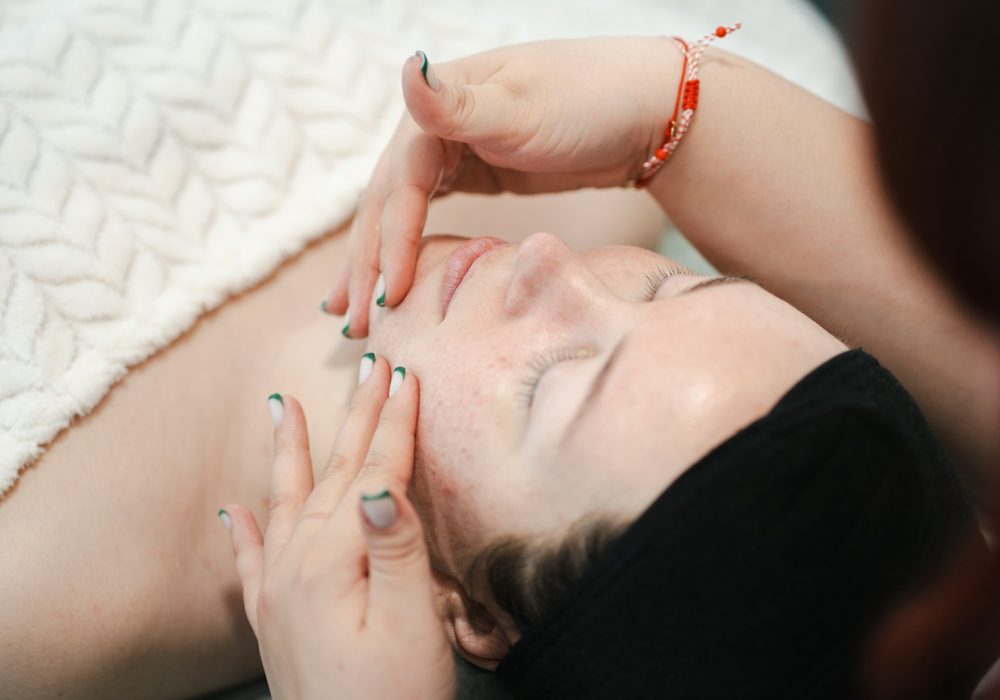 Woman enjoying a facial massage with closed eyes.