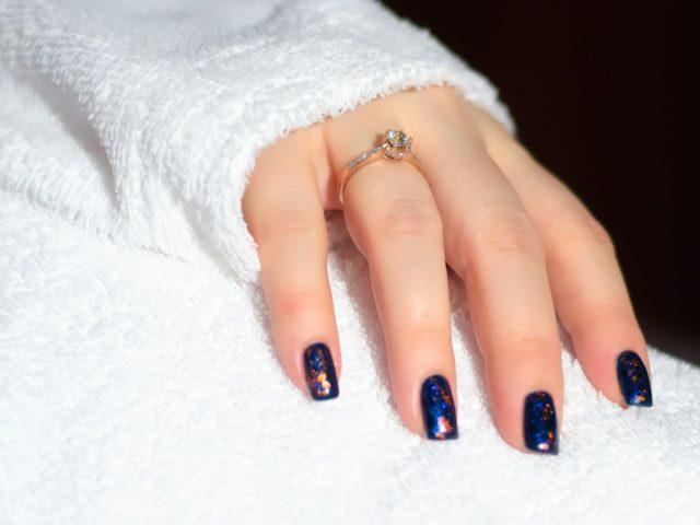 a woman's hand with a blue and white manicure