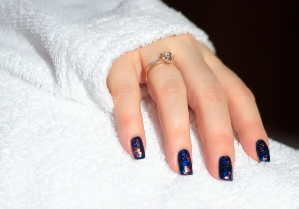 a woman's hand with a blue and white manicure