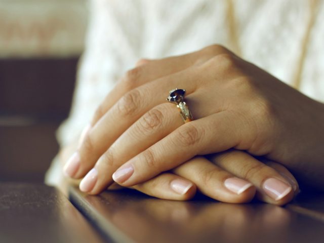 person wearing silver-colored ring with black gemstone