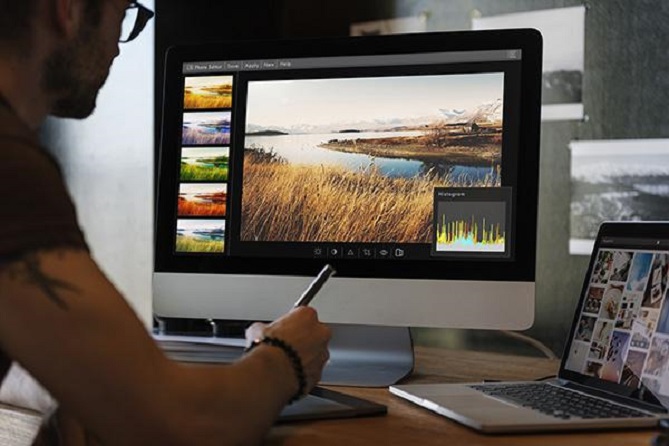 Um designer gráfico editando fotos em seu tablet