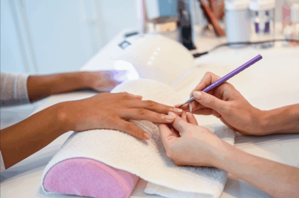 A manicurist grooming a client’s nail