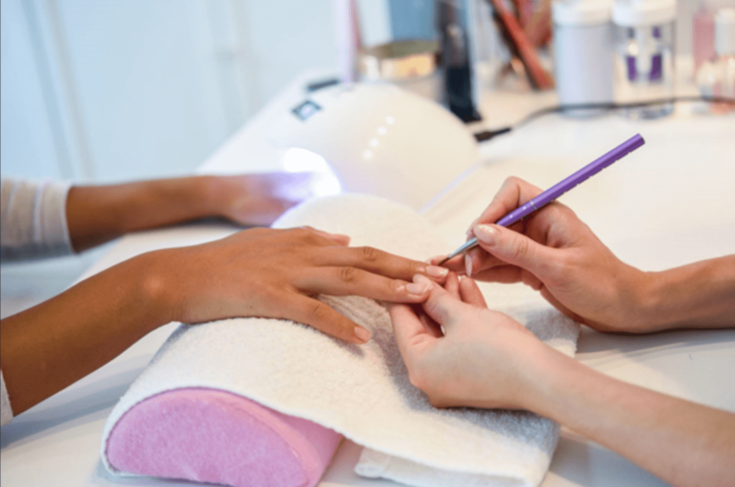 A manicurist grooming a client’s nail