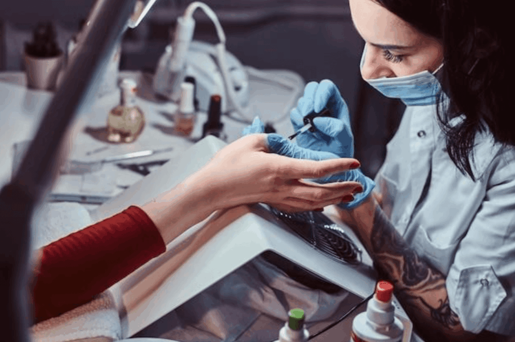 Female beautician doing a client’s nails after completing online nail class