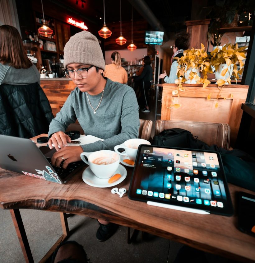 a man sitting at a table working on a laptop